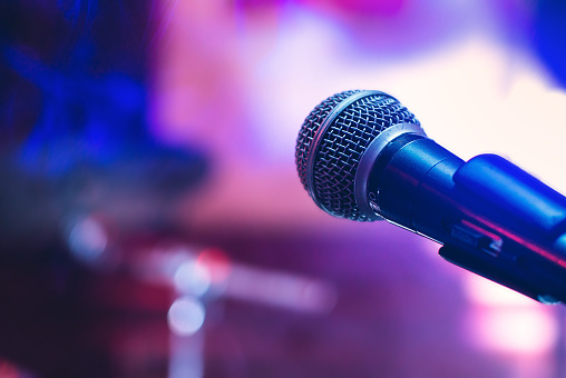 Microphone on the stage on violet background