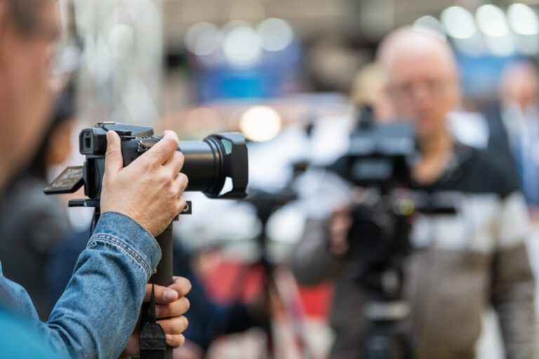 A professional photographer documenting the highlights of the opening ceremony with precision and expertise