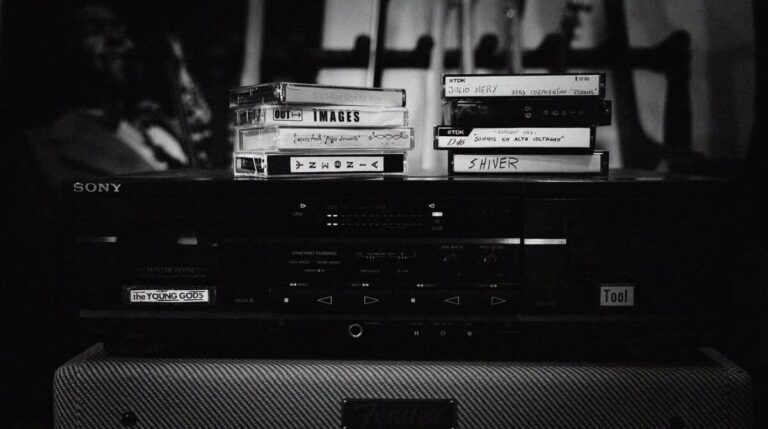 Black-and-white image of a Sony stereo with cassette tapes stacked on top.