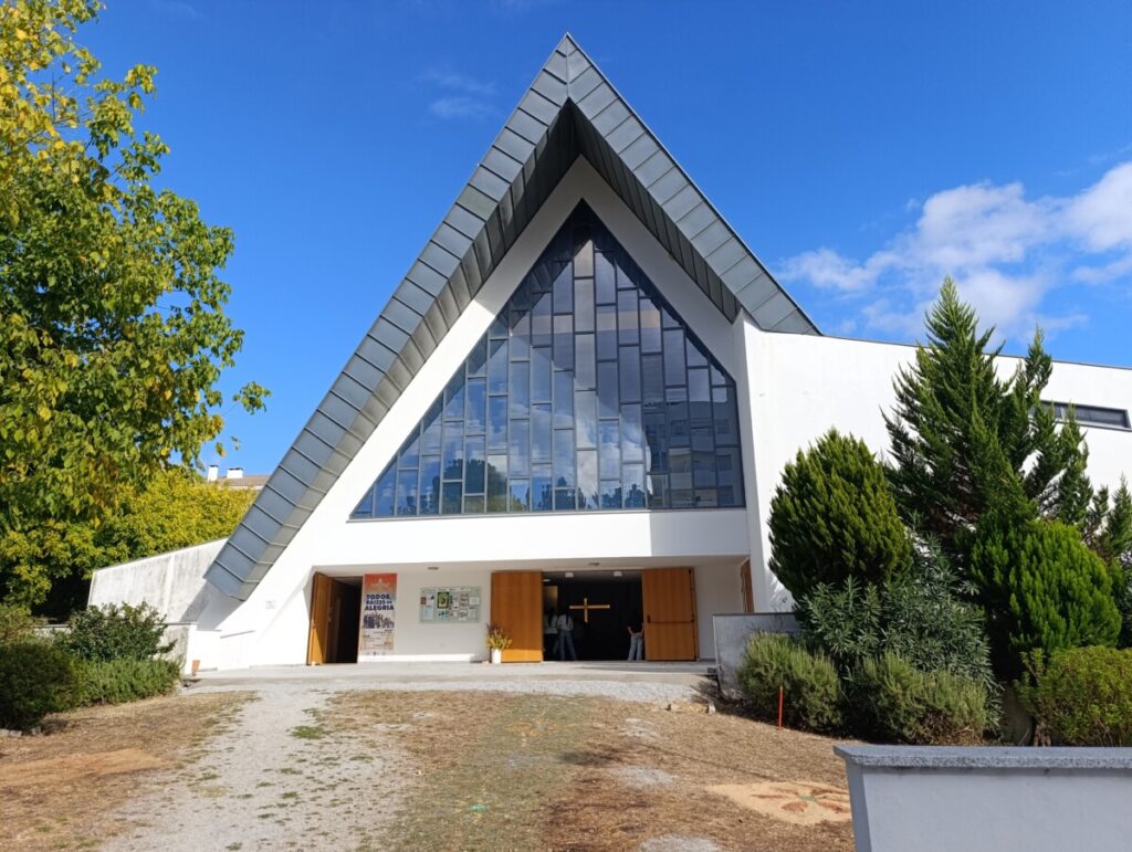 Modern church with a tall triangular glass facade and open wooden doors under a sharp pitched roof, blue sky above. Diocese de Viseu celebra 20 anos da beatificação da Beata Rita Amada de Jesus