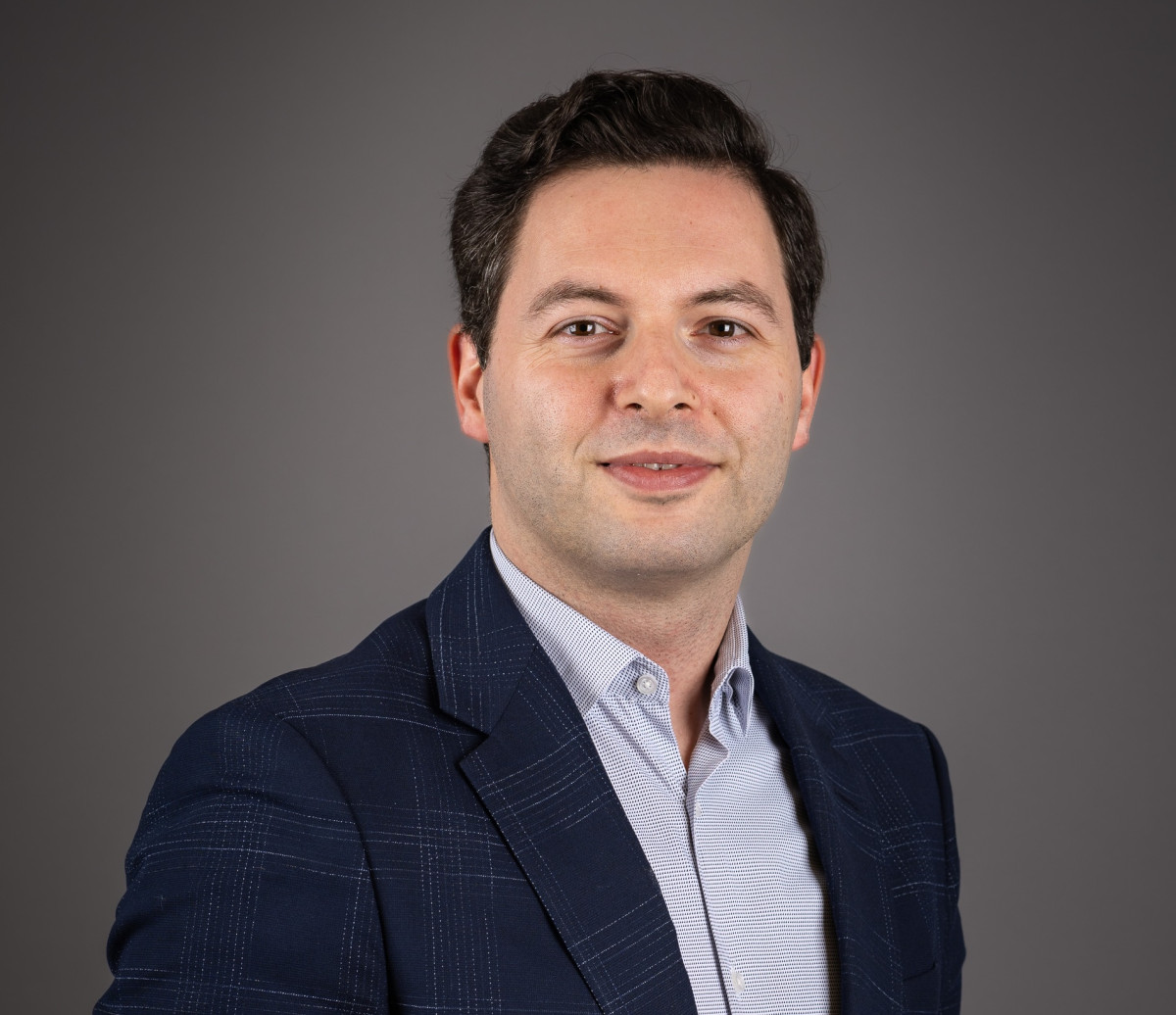 Professional headshot of a man in a navy blazer and light shirt, smiling at the camera. Descomplicar o procedimento administrativo