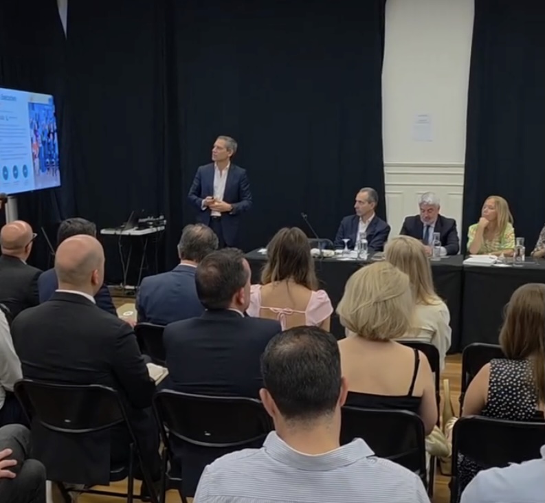 Man in a suit standing and presenting to a panel of five seated people at a conference. Viseu vai integrar nova escola de formação de executivos da Universidade Católica Portuguesa