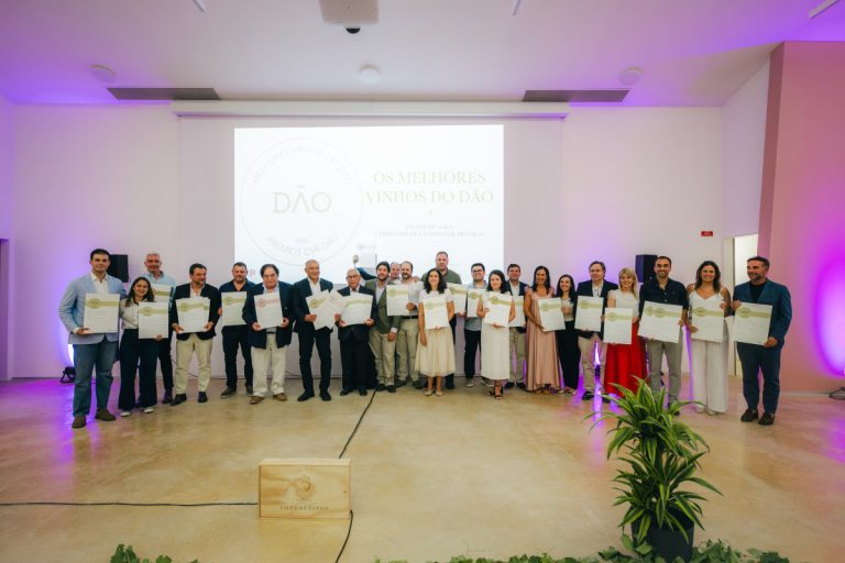 Group of people on stage holding certificates at an awards ceremony, posed for a photo.
