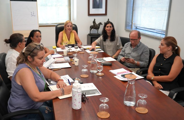 Group of professionals seated around a conference table reviewing documents during a meeting.