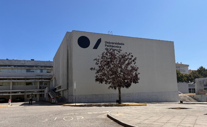 Exterior view of a concrete university building with the 'Universidade Politécnica de Viseu' logo and a tree in front.