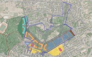 Aerial map of a planned area showing a blue dashed boundary outlining a large park and surrounding development with color‑coded zones in yellow, orange, blue, and brown. Roads and residential blocks are visible inside and around the boundary.